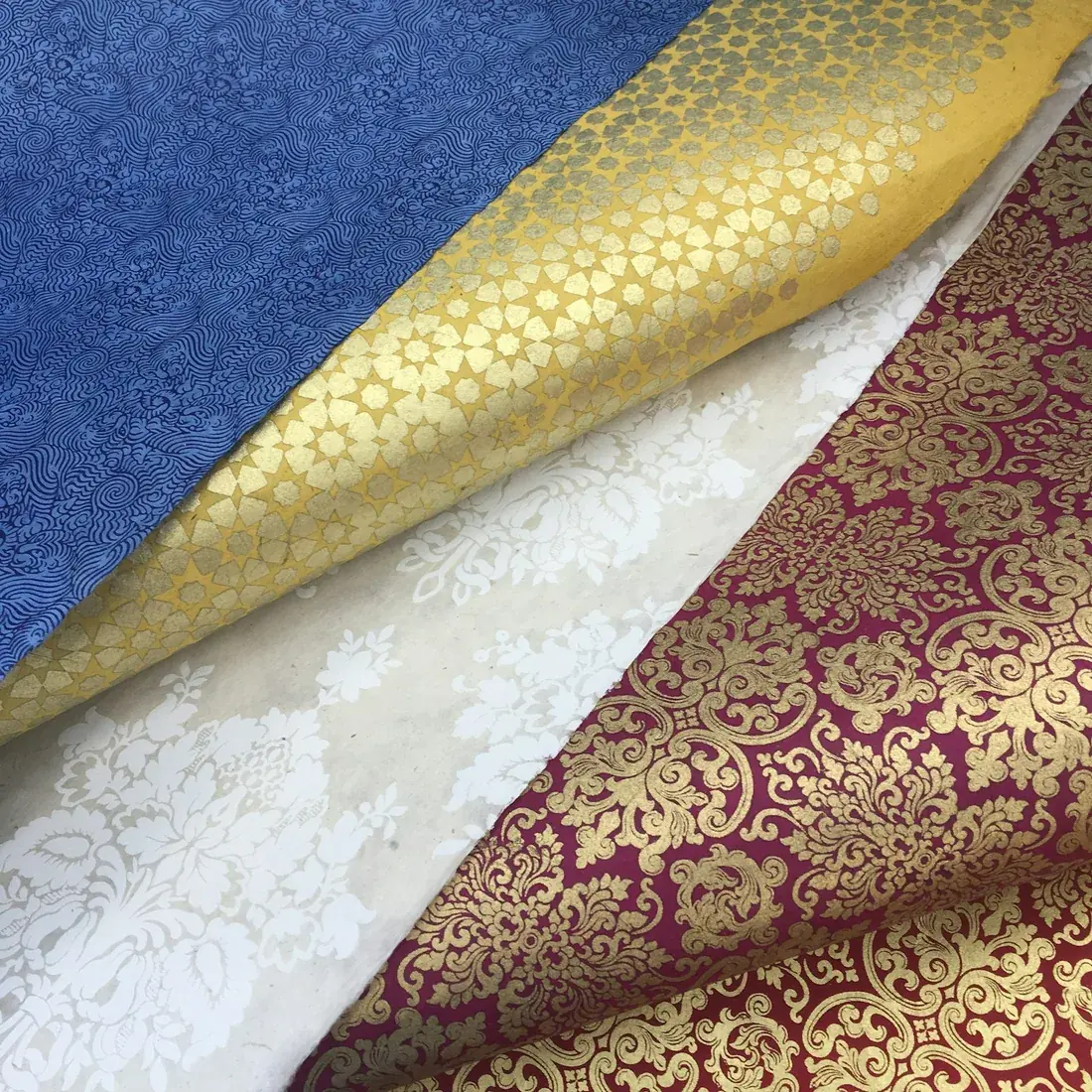 Telas de tapicería de distintos colores y texturas apiladas una junto a otra